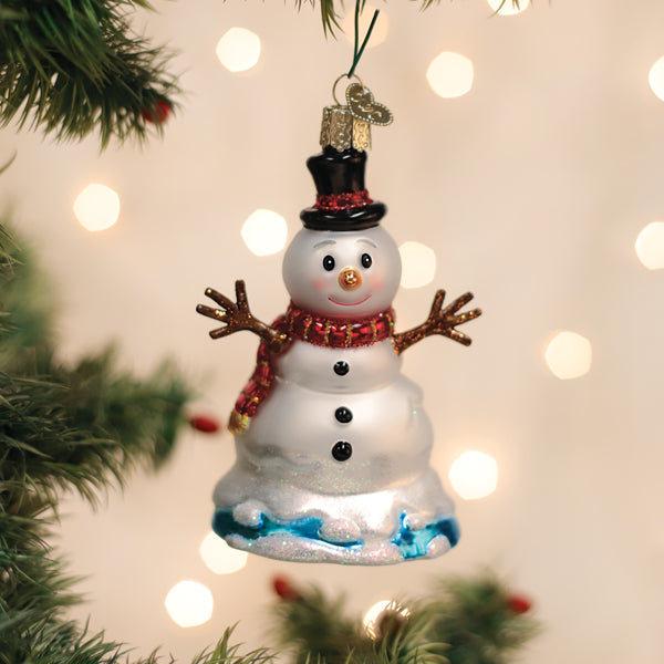 Decorative snowman ornament on a Christmas tree with lights in the background