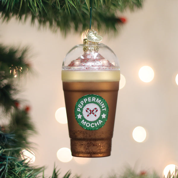 Peppermint Mocha ornament hanging on a Christmas tree with lights in the background.