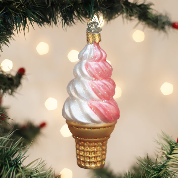 Decorative ice cream cone ornament on a Christmas tree with blurred lights in the background.
